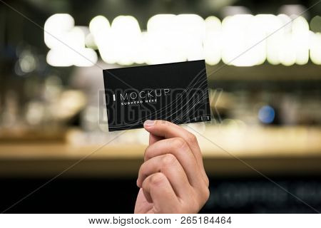 Female hand holding a black business card mockup