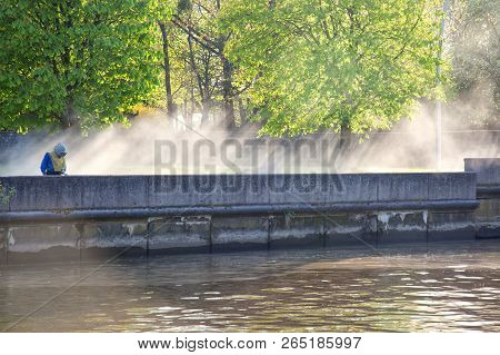 Worker Removes Dirt From The Parapet On The Embankment Of The Pregolya River In The City Of Kalining