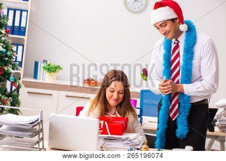Colleagues exchaing christmas presents in office