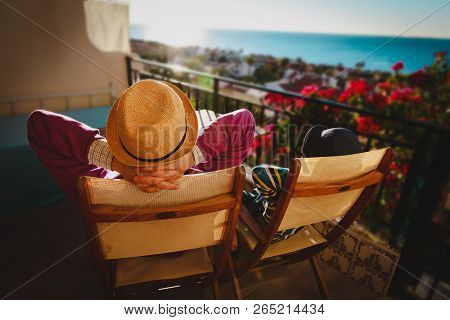 Dad And Son Relax On Balcony Terrace With Sea View