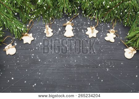 Christmas Decorations With Cookies, Fir Tree Branches And On Dark Background With Copyspace.