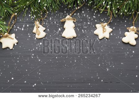 Christmas Decorations With Cookies, Fir Tree Branches And On Dark Background With Copyspace.
