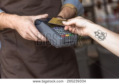 Cropped Shot Of Waiter Holding Payment Terminal While Customer Doing Contactless Purchase With Credi