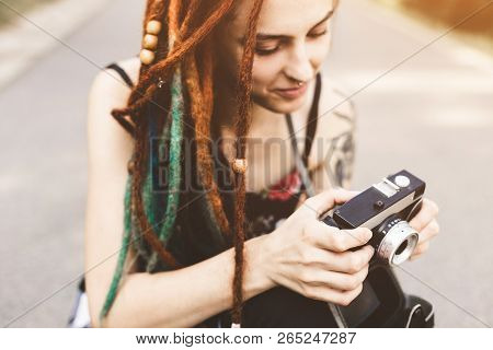 Young Girl With Tattoos And Dreadlocks Photographs Vintage Camera In The Park