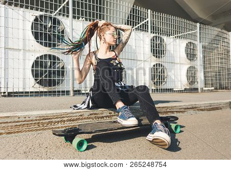 Young Girl With Tattoo And Dreadlocks On Urban Industrial Background