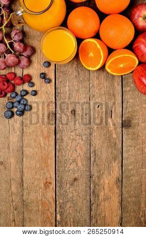 Orange Juice, Fresh Oranges, Apples, Grapes, Raspberries And Blueberries On A Wooden Table - Fruit B