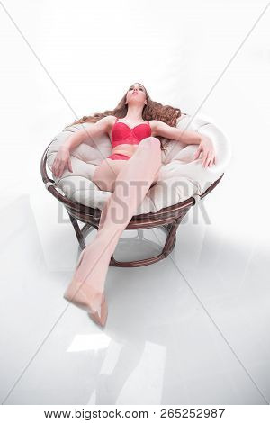 Beautiful Woman In Red Underwear Relaxing In A Round Chair Papasan .photo With Copy Space