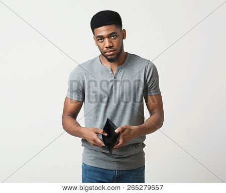 Financial Crisis And Bankruptcy. Unhappy Sad Man Showing Empty Wallet, White Studio Background