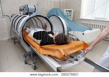 The Girl Is Undergoing A Medical Procedure In A Hyperbaric Chamber.