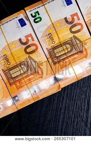 Pile Of 50 Real Euro Notes 50-euro Banknotes Under Rubber Band Isolated On Black. About 20000 Euros 