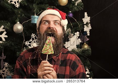 Winter Holiday And Xmas. Christmas Man With Beard On Happy Face And Lollipop. Santa Claus Man In Hat
