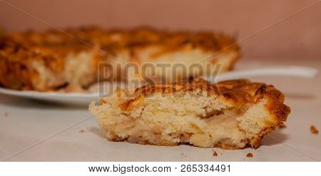 Fresh Slice Of Apple Pie With Whole Pie In Background