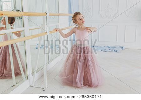Young Classical Ballet Dancer Girl In Dance Class. Beautiful Graceful Ballerina Practice Ballet Posi