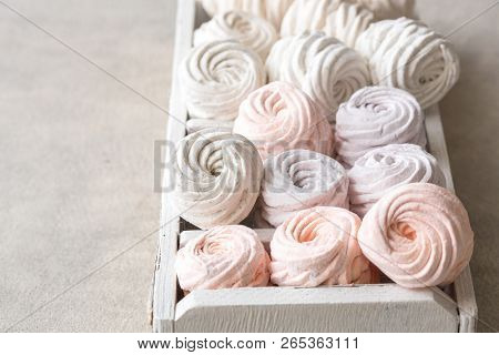 Colorful Zephyr And Grape On White Wooden Background.set Of Homemade White And Pink Zephyr Or Marshm