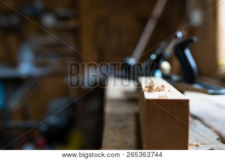 Wood Chip On Focus, Pine Board, Oak Worbench,  Carpentry Tools On The Blurried Background, Workshop,