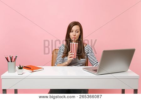 Concentrated Woman Drinking From Plactic Cup With Cola Soda Working On Project At Office At White De