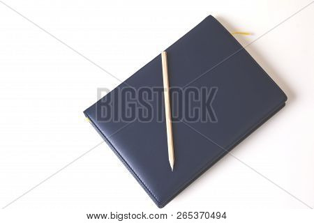 Closed Notepad With Pencil On White Background