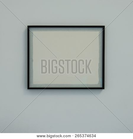 Baguette Frame With A White Blank Sheet On The Wall. For Web Design.