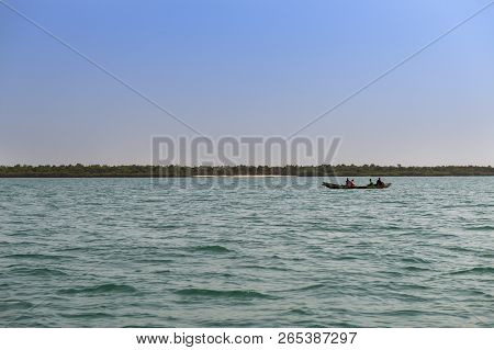 Orango Island, Guinea-bissau - February 3, 2018:  Fishermen In An Old Traditional Fishing Canoe Near