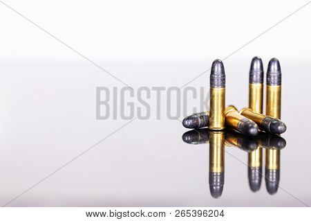 Group Of Ammunition On A Table With Reflections, White Background