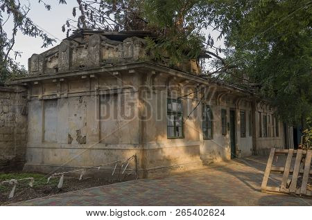 Old Destroyed Stone House On The Yard With Trees Around. Poverty And Misery, South, Summer
