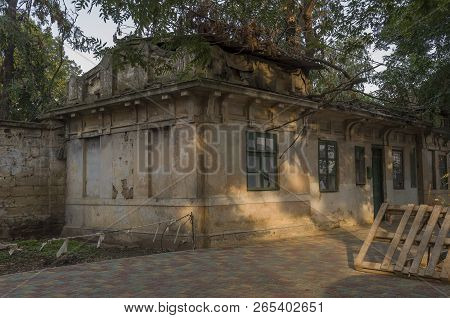 Old Destroyed Stone House On The Yard With Trees Around. Poverty And Misery, South, Summer