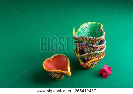 Colorful handcrafted traditional Diwali lamps stacked on eatch other. Beautiful Diwali festive background and objects.
