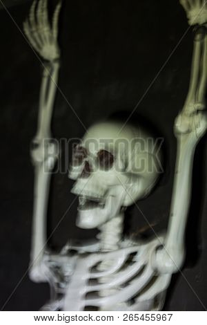 Skeleton Hanging In The Darkness Ready To Scare People. Intentional Motion Blur To Convey Movement A