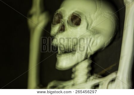 Skeleton Hanging In The Darkness Ready To Scare People. Intentional Motion Blur To Convey Movement A