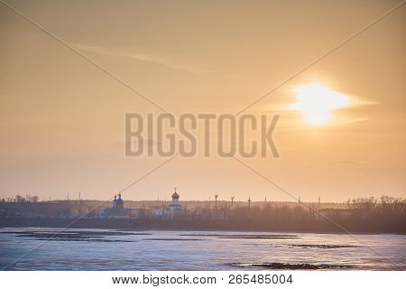 Sunset Over The Orthodox Monastery. Russian City In The Spring, Ice On The River