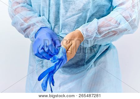 Handsome Young Doctor Putting On Rubber Gloves In Hospital Or Clinic
