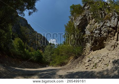 seinor male hiker relaxing in nature while  walking tour on beautiful summer day on canyon of  dried riverbed