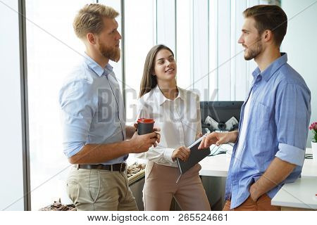 Group Of Young Modern People In Smart Casual Wear Having A Brainstorm Meeting While Standing In The 