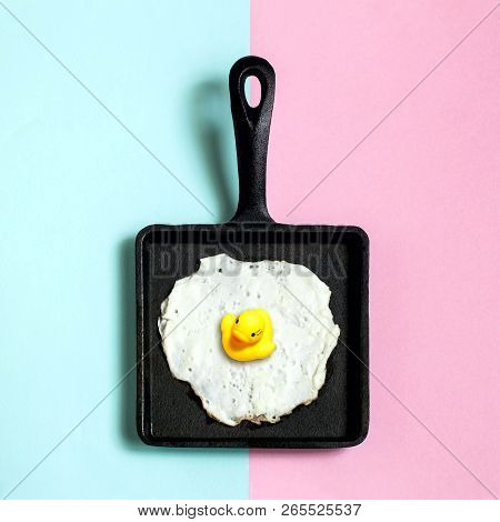 Square Cast-iron Frying Pan With Fried Eggs, Toy Duckling Instead Of Yolk. Artificial Objects That M