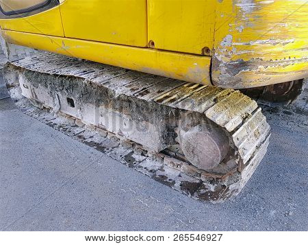 Lower Section Of Yellow Excavator Showing Grouser Pads And Sprockets