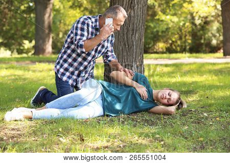 Passerby Calling Ambulance For Woman With Heartache Outdoors. First Aid