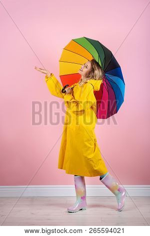 Woman With Rainbow Umbrella Near Color Wall