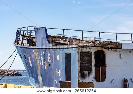 Horizontal close up of an old, dilapidated ship being taken apart for scrap, in Caraquet, New Brunswick