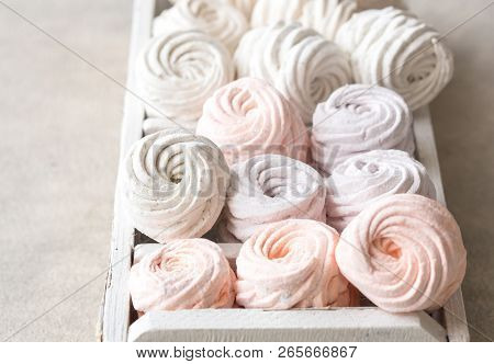 Colorful Zephyr And Grape On White Wooden Background.set Of Homemade White And Pink Zephyr Or Marshm
