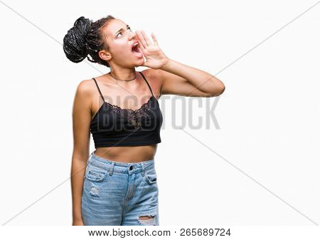 Young braided hair african american with pigmentation blemish birth mark over isolated background shouting and screaming loud to side with hand on mouth. Communication concept.
