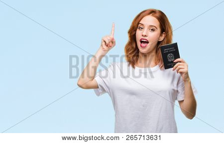 Young beautiful woman holding passport of italy over isolated background surprised with an idea or question pointing finger with happy face, number one