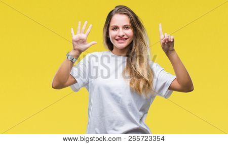 Young beautiful blonde woman wearing casual white t-shirt over isolated background showing and pointing up with fingers number six while smiling confident and happy.