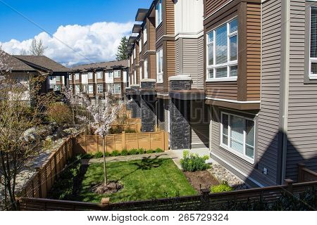 New Modern Low Rise Appartament Complex On A Sunny Spring Day With Blooming Sakura Trees.