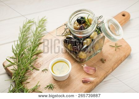 Various Olives Marinated In A Jar. Garlic, Rosemary, Olive Oil And Spices. Rustic Style