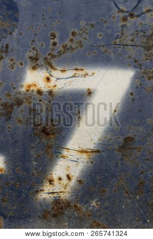 White Number Seven Painted On Rusty Blue Metal