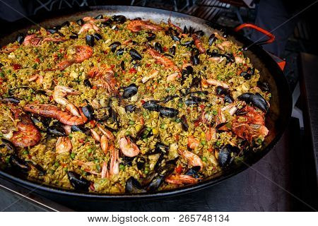 Seafood Paella With Rice, Tomato Sauce, Langoustine, Mussels, Squid, Shrimp.