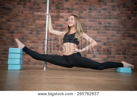 Beautiful Young Woman Does The Splits In Pole Dance Studio