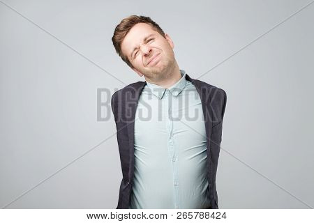 Tired European Attractive European Man In Shirt And Suit, Pulling Hands Back While Stratching