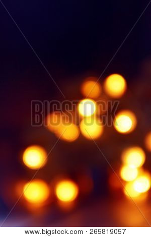 Background Of Blurry Yellow-orange Lights Of Christmas Tree Garland On Dark. Copy Space.