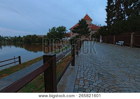 Old Brick Road To The Historic Center Of Telc. The Castle Of Telc And The Gate To The Main Square Of